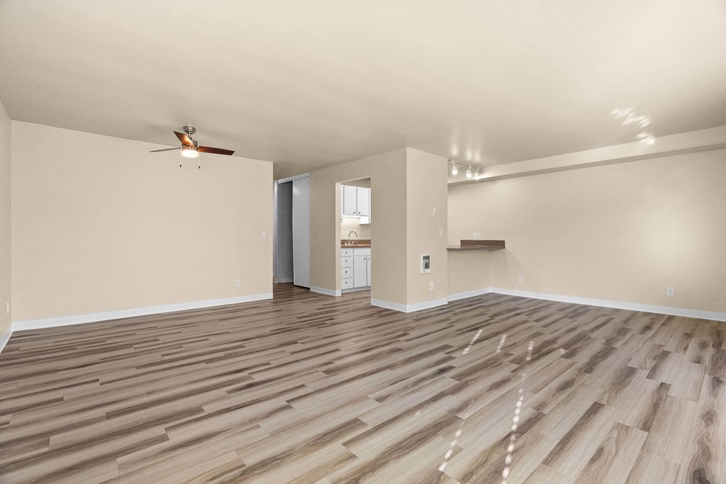 A room with wooden flooring and a ceiling fan.