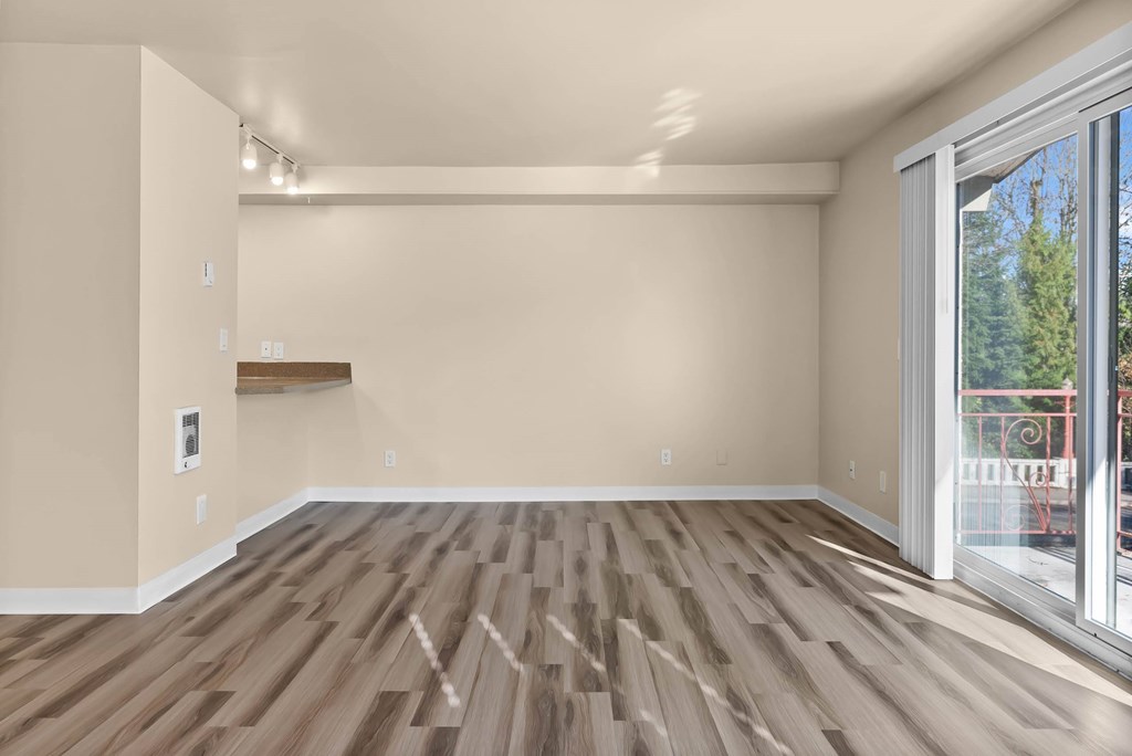 A room with wooden flooring and a sliding glass door.