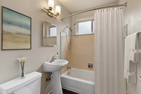 A bathroom with a white sink, toilet, and bathtub.