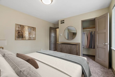 A bedroom with a bed, wardrobe, and a mirror.