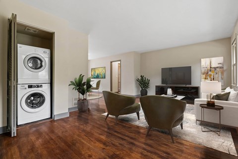 A modern living room with a washing machine in the doorway.