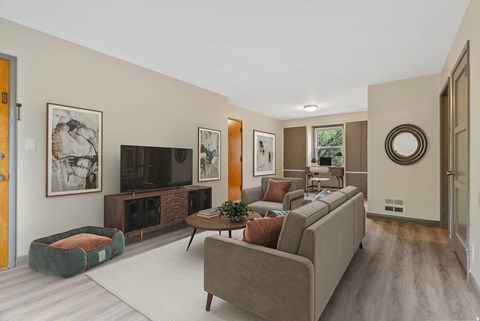 A living room with a grey couch and a green dog bed.