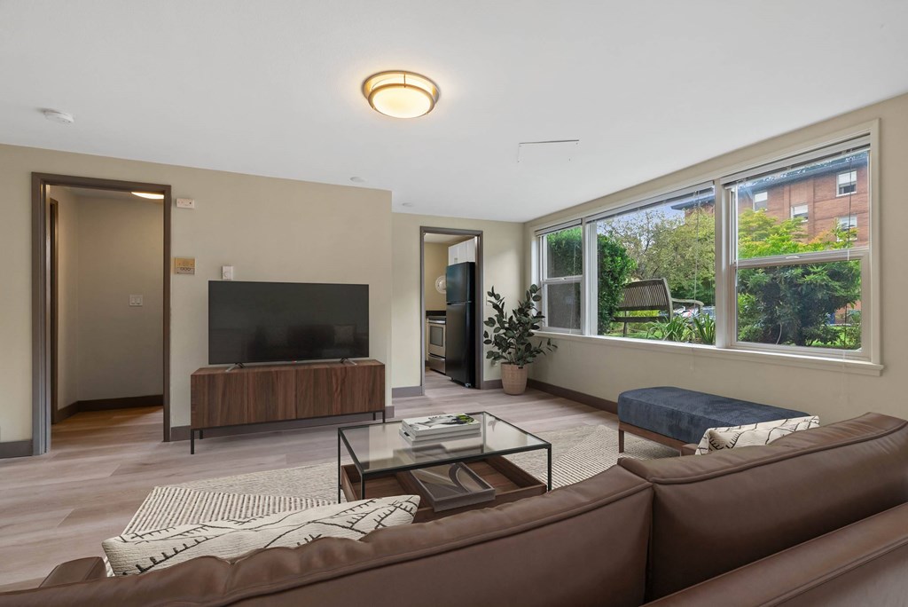 A modern living room with a brown leather couch and a flat screen TV.