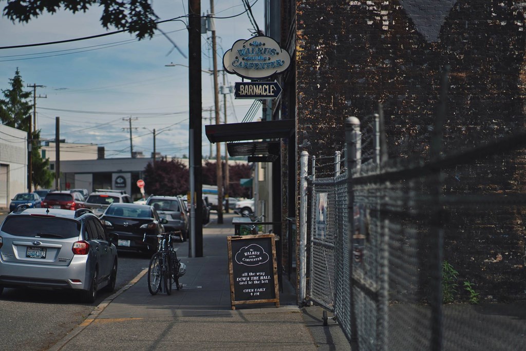 A street view of a parking lot with cars and a sign that says
