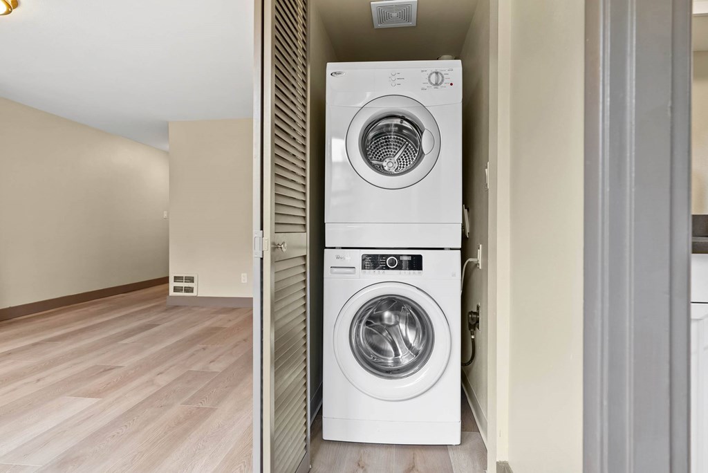 A white front loading washing machine in a laundry room.