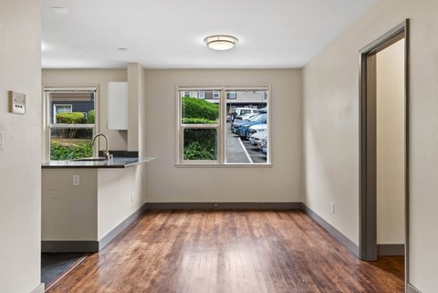 A kitchen with a window overlooking a parking lot.