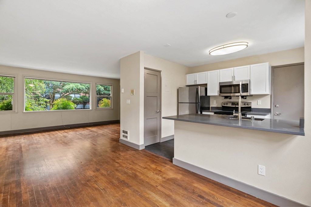 A kitchen with a refrigerator, microwave, and oven built into a wall.