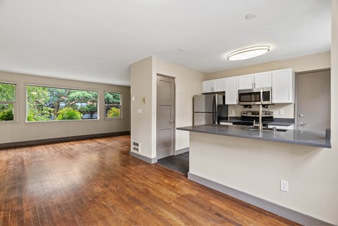 A kitchen with a refrigerator, microwave, and oven built into a wall.