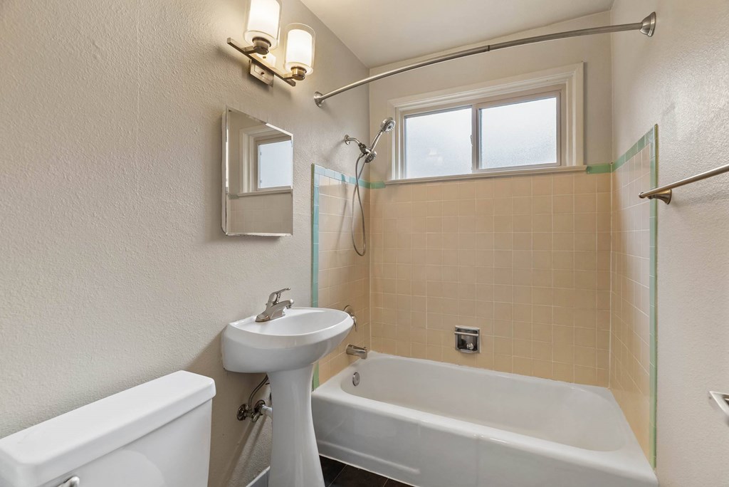 A white sink and toilet in a bathroom with a glass shower door.