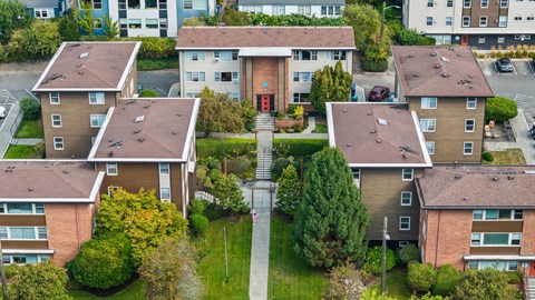 Apartment complex with a central courtyard and a red sign on the building.