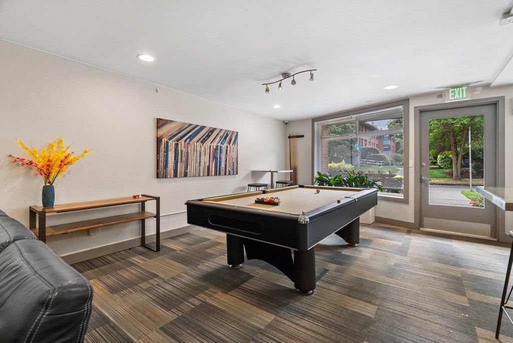 A room with a pool table and a bench.