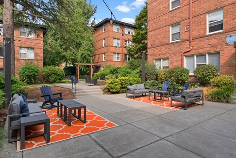 A patio with a table and chairs surrounded by a brick building.