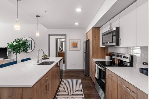 A modern kitchen with wooden cabinets and a white countertop.