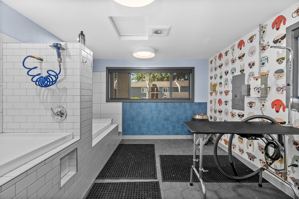 A bathroom with a white tub and a blue wall.