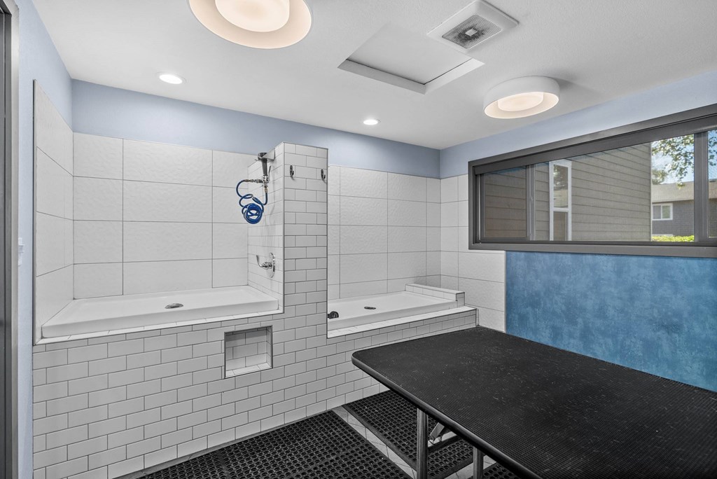 A modern bathroom with a black countertop and white tiles.