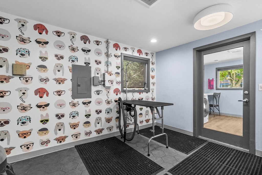 A room with a table and chairs and a wallpaper with cartoon animals.