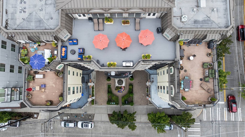 A top-down view of a courtyard with a fountain, seating areas, and greenery.