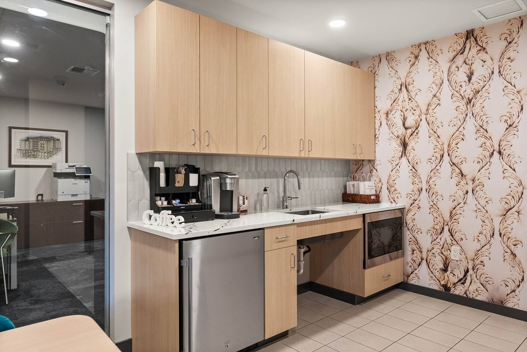 A kitchen with wooden cabinets and a patterned wallpaper.