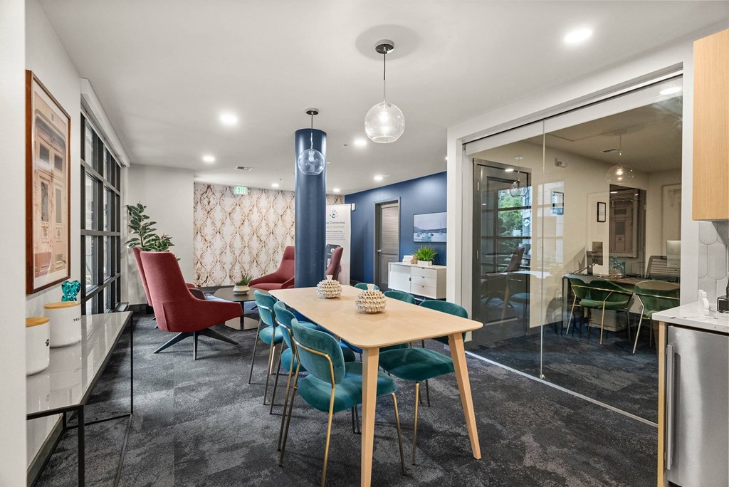 A dining room with a table surrounded by chairs.