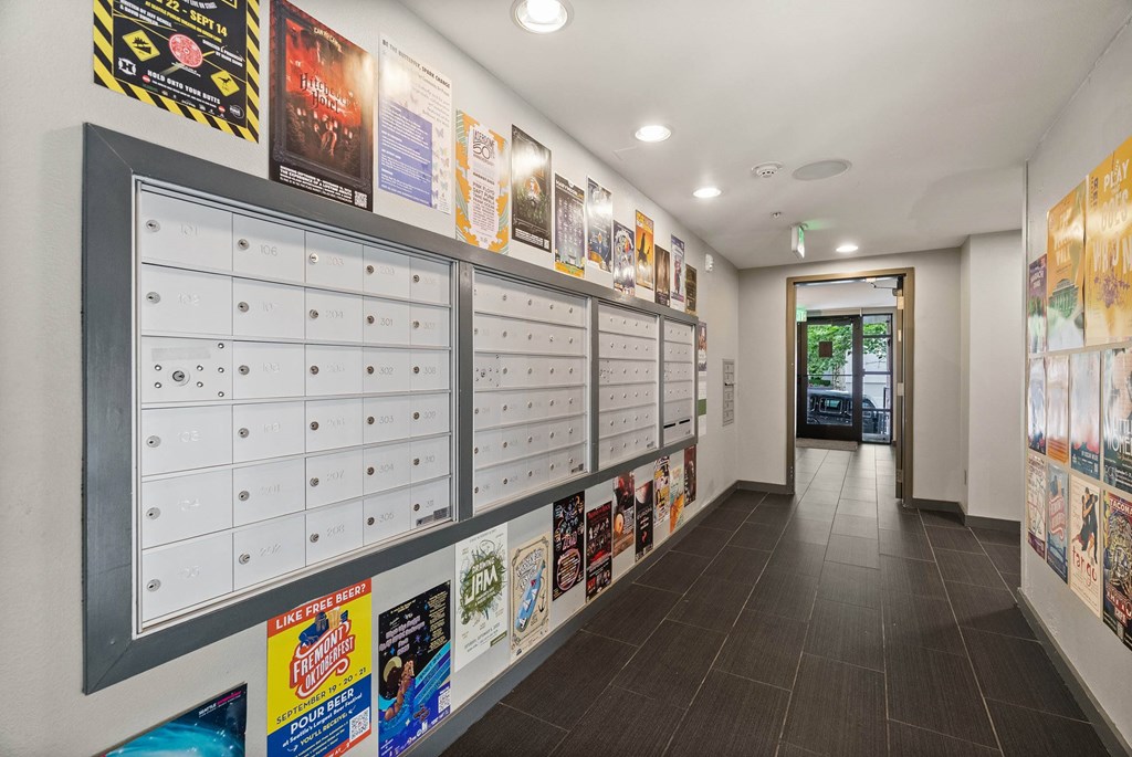 A hallway with a series of posters on the wall.