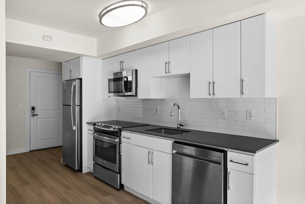 A modern kitchen with stainless steel appliances and white cabinets.