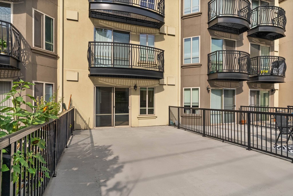 A balcony of a building with a black railing.