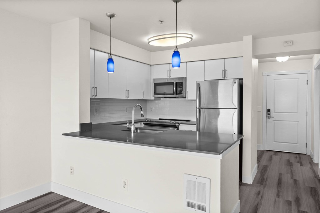 A modern kitchen with a stainless steel refrigerator and a center island.