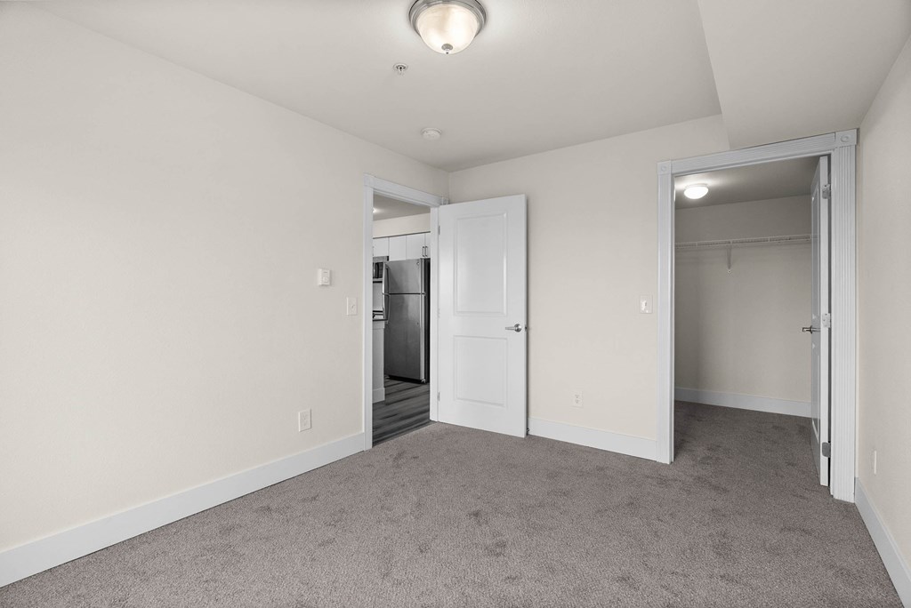 A room with a carpeted floor and a white door.