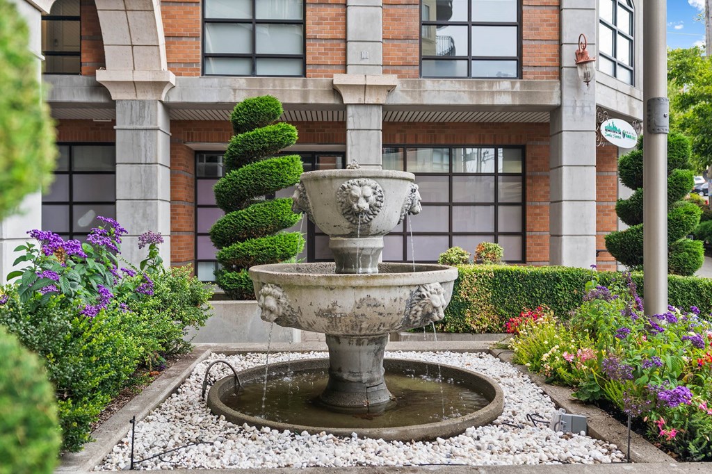 A stone fountain in the middle of a garden.