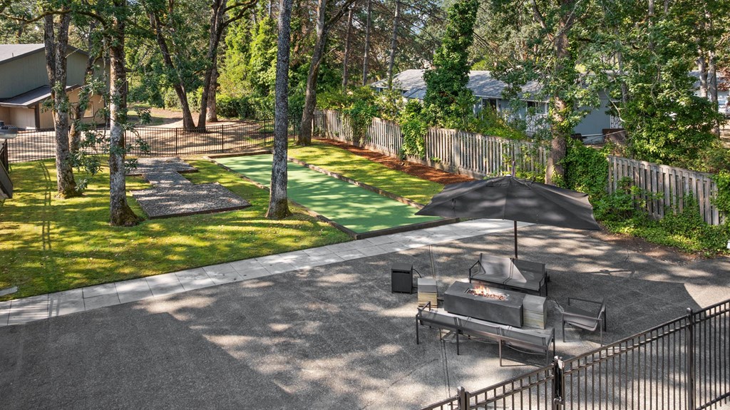 A backyard with a BBQ grill and a fence.
