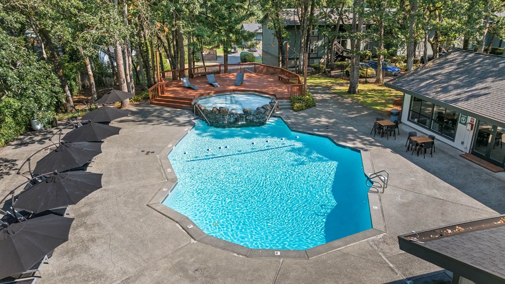 A swimming pool surrounded by trees and a deck.