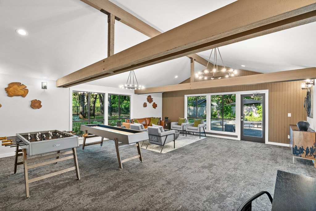 A room with a billiard table and a foosball table.