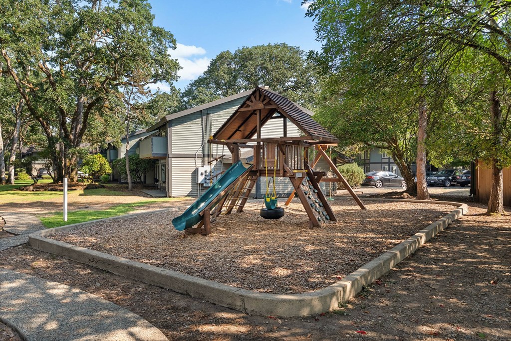 A playground with a slide and a swing set.