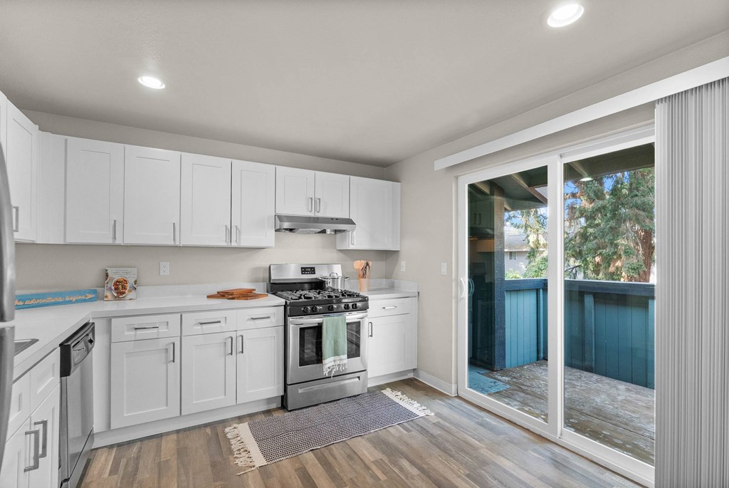 A modern kitchen with white cabinets and stainless steel appliances.