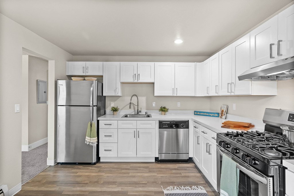 A kitchen with white cabinets and a stainless steel refrigerator.