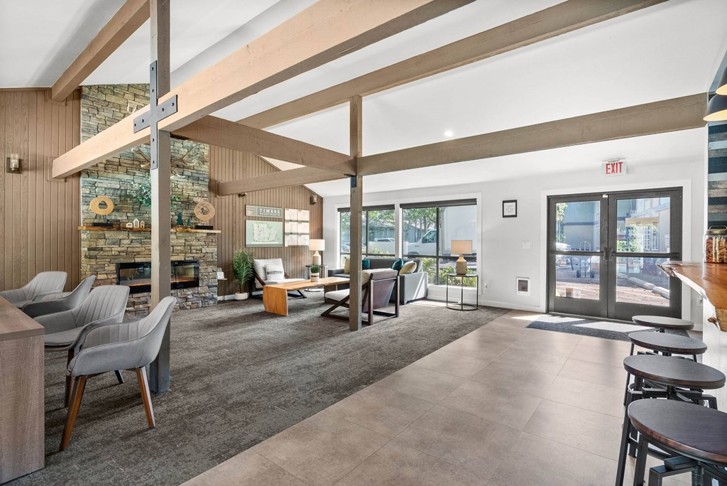 A modern interior with a stone fireplace and wooden beams.