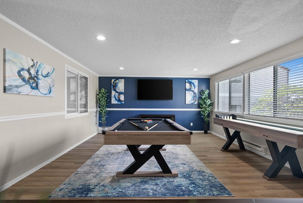 A room with a blue rug and a wooden table.