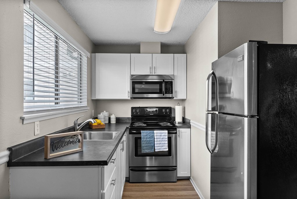 A modern kitchen with a black fridge and stove.