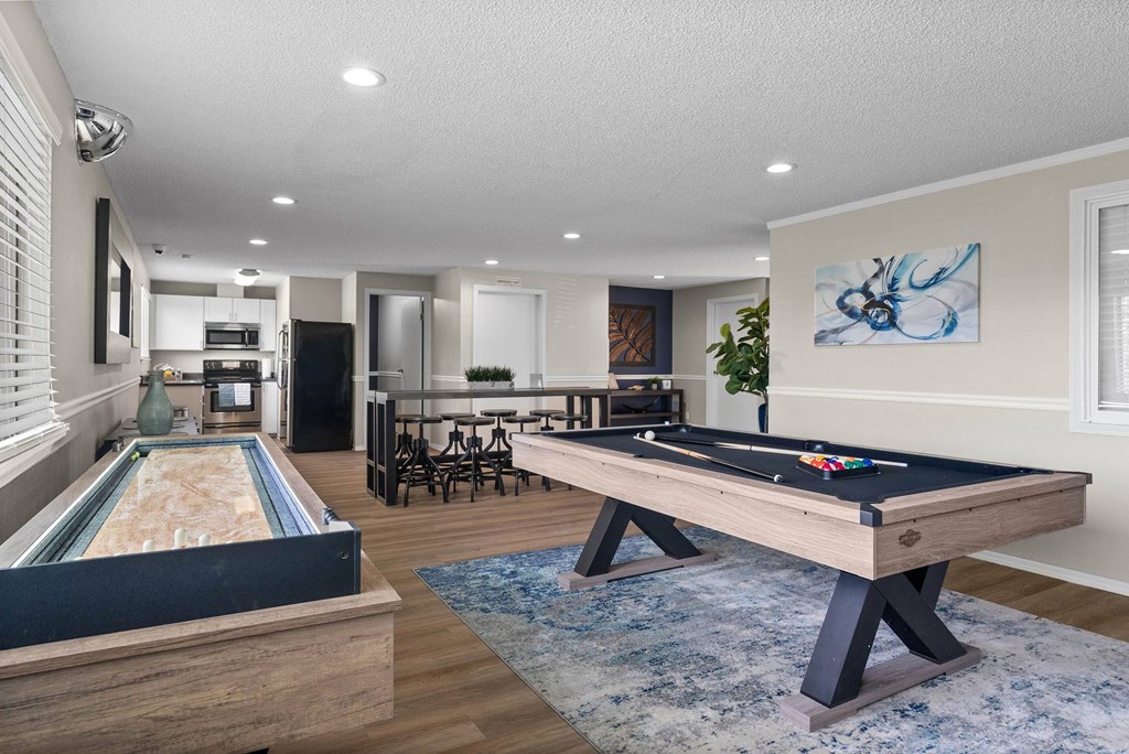 A pool table in a room with a dining table and chairs.