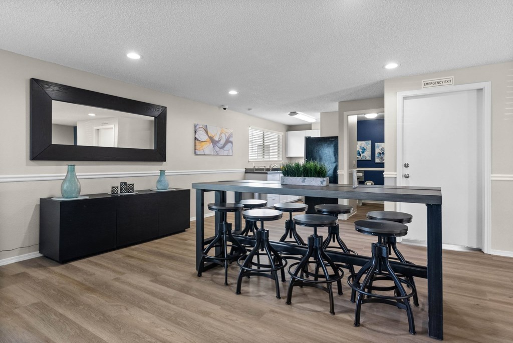 A modern kitchen with a black countertop and bar stools.