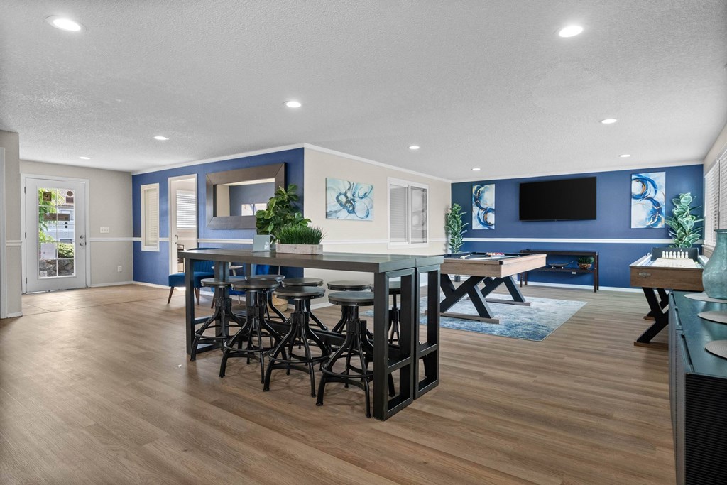 A modern kitchen with a bar area and a dining table.