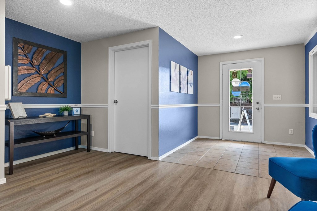 A room with a blue chair and a bed.