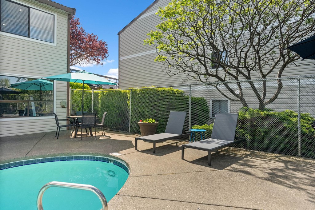 A pool with a chair and a table in the backyard.