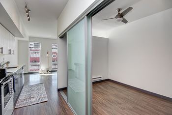 an empty living room with a sliding glass door to a kitchen at Icon Apartments, Washington, 98104