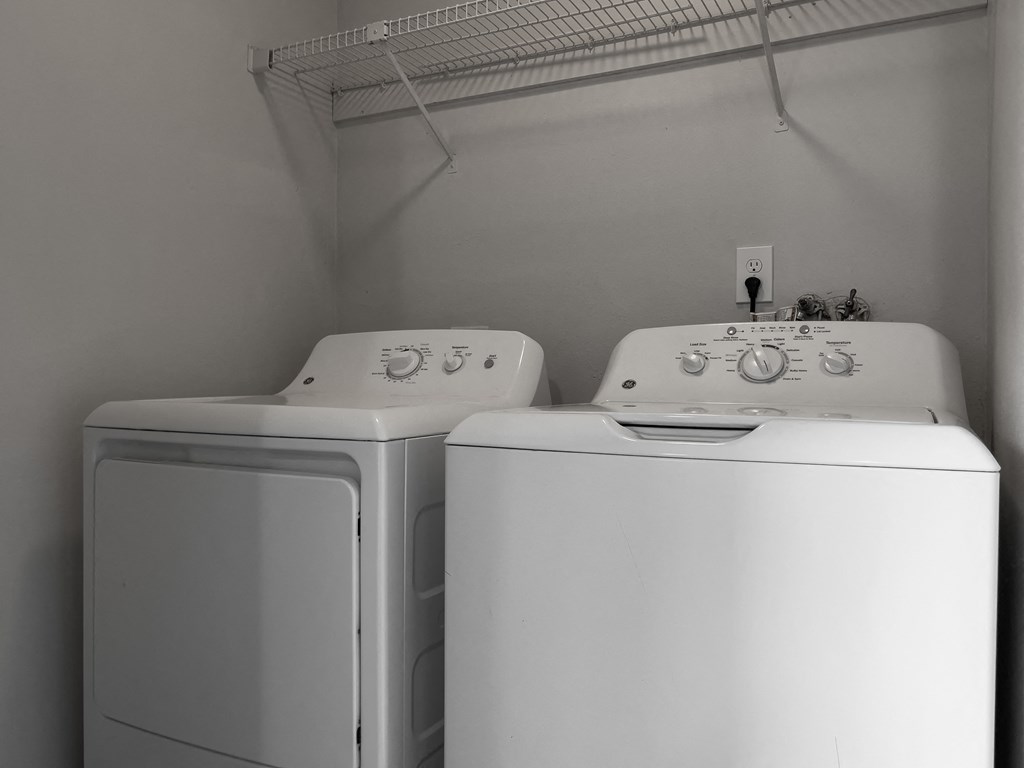 two washers and a dryer in a laundry room