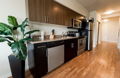 A kitchen with dark wood cabinets and stainless steel appliances.