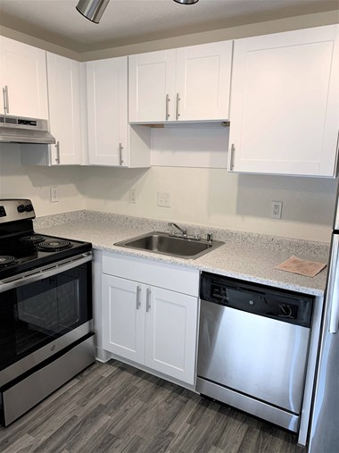a kitchen with white cabinets and stainless steel appliances
