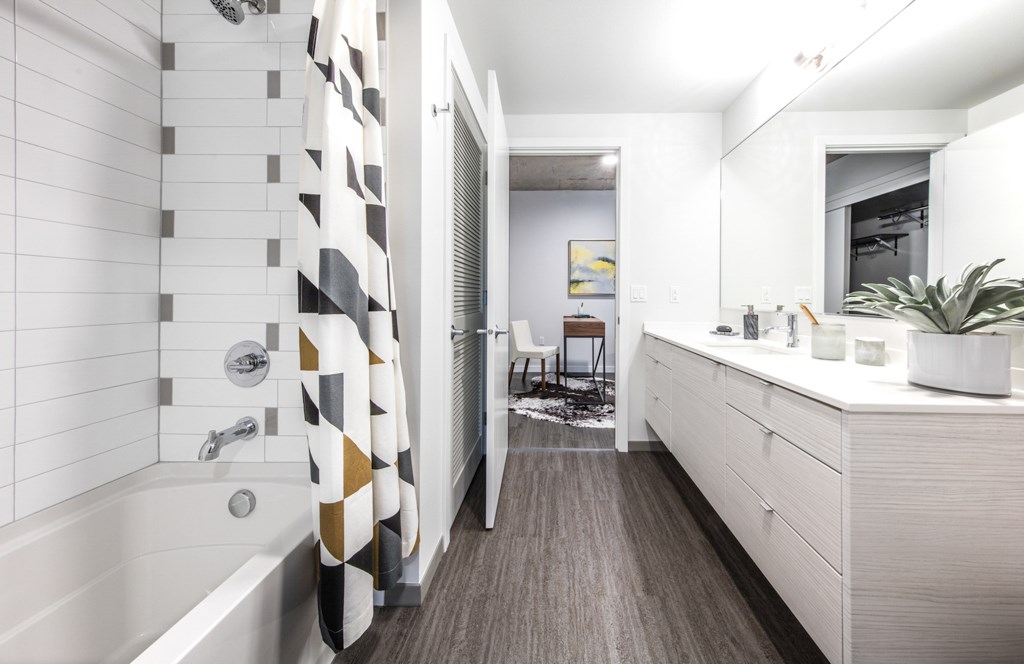 A bathroom with a white tub and a white sink.