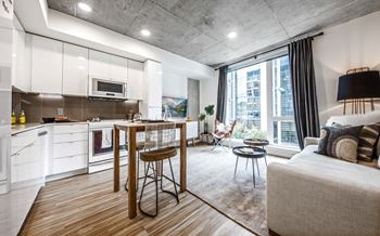 A modern kitchen with a dining table and a couch in the living room.