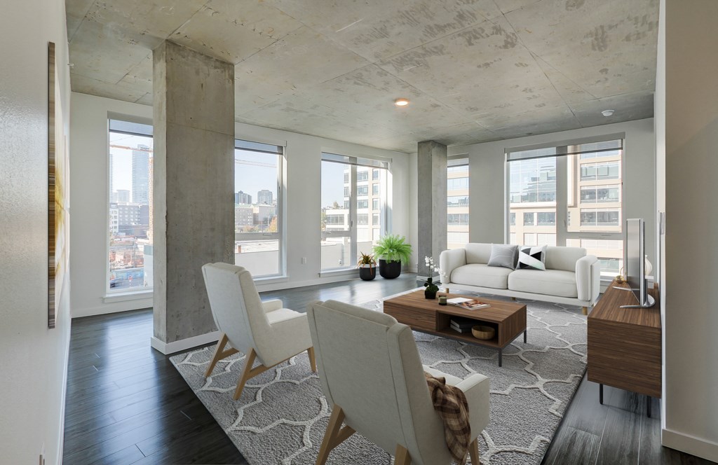 A modern living room with a white sofa and a large window overlooking the city.